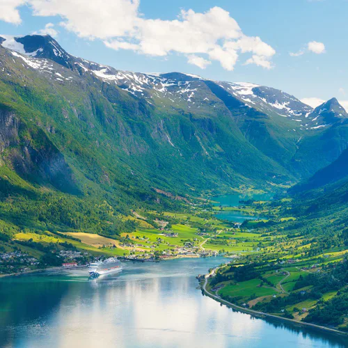 Norway. Cruise ship in the Norwegian fjord. High mountains and reflections on the surface of the water. Clouds over the rocks. Vacation and travel in summer Norway.