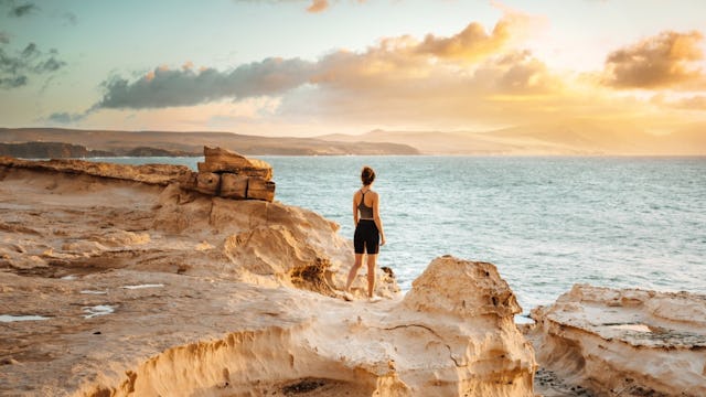 Woman standing on a cliff in Fuerteventura, Canary Islands