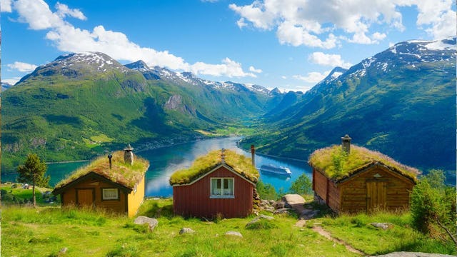 Nature in fjords. Rakssetra, Norway. Panoramic view. Traveling on a Norwegian fjord. Scandinavia. Traditional old settlement. Houses with moss on the roof.