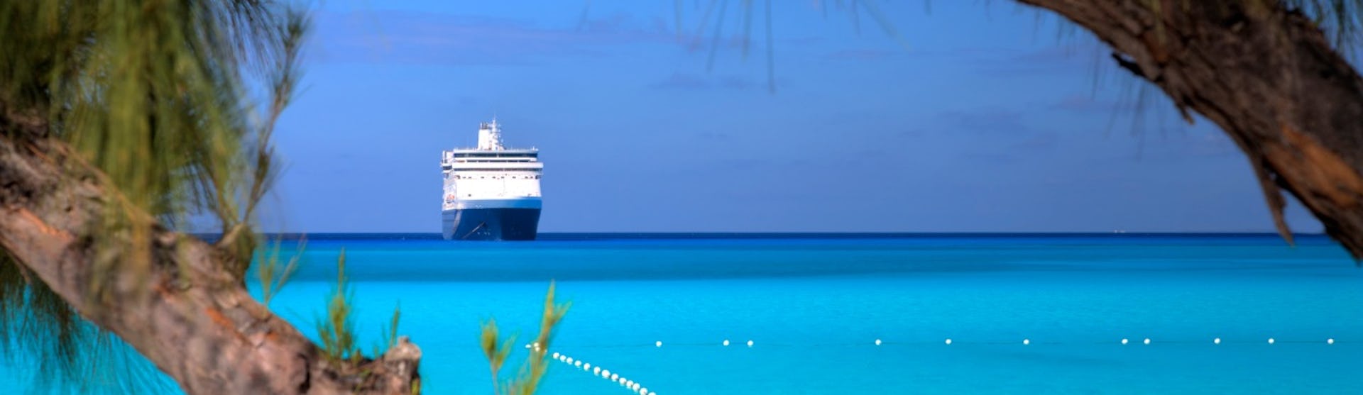 A ship waits on the horizon on a beautiful beach in the Caribbean