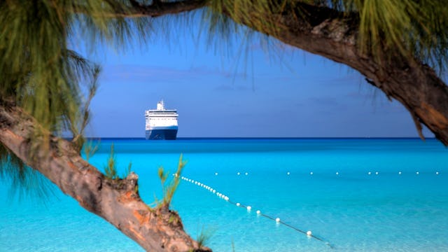 A ship waits on the horizon on a beautiful beach in the Caribbean
