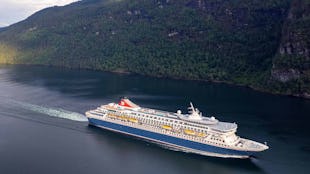 Fred Olsen Balmoral Cruise Ship sailing through a green valley