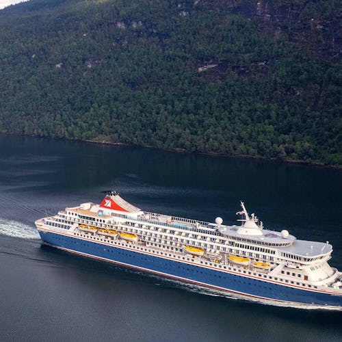 Fred Olsen Balmoral Cruise Ship sailing through a green valley
