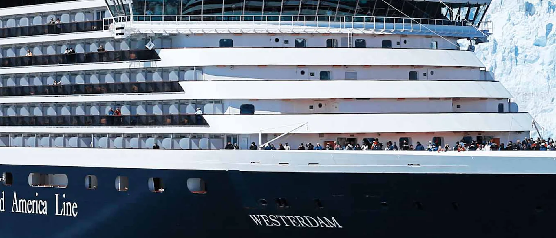 Holland America Westerdam cruise ship sailing through snowy mountains