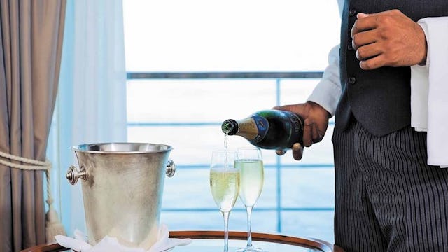 Butler pouring two glasses of champagne