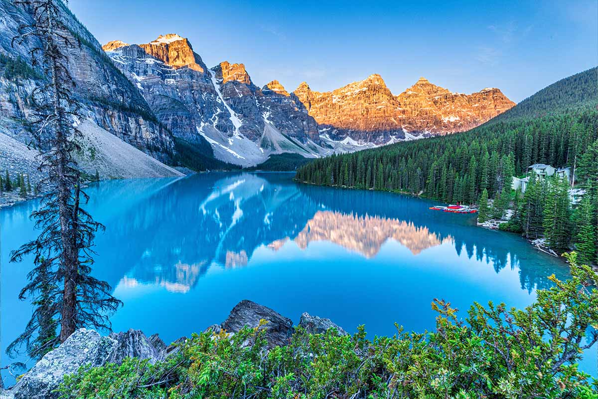 Moraine Lake in Alberta Canada 

 - Beautiful Sunrise with Lighted Mountain Peaks, Incredible Reflection and Amazing Blue Water