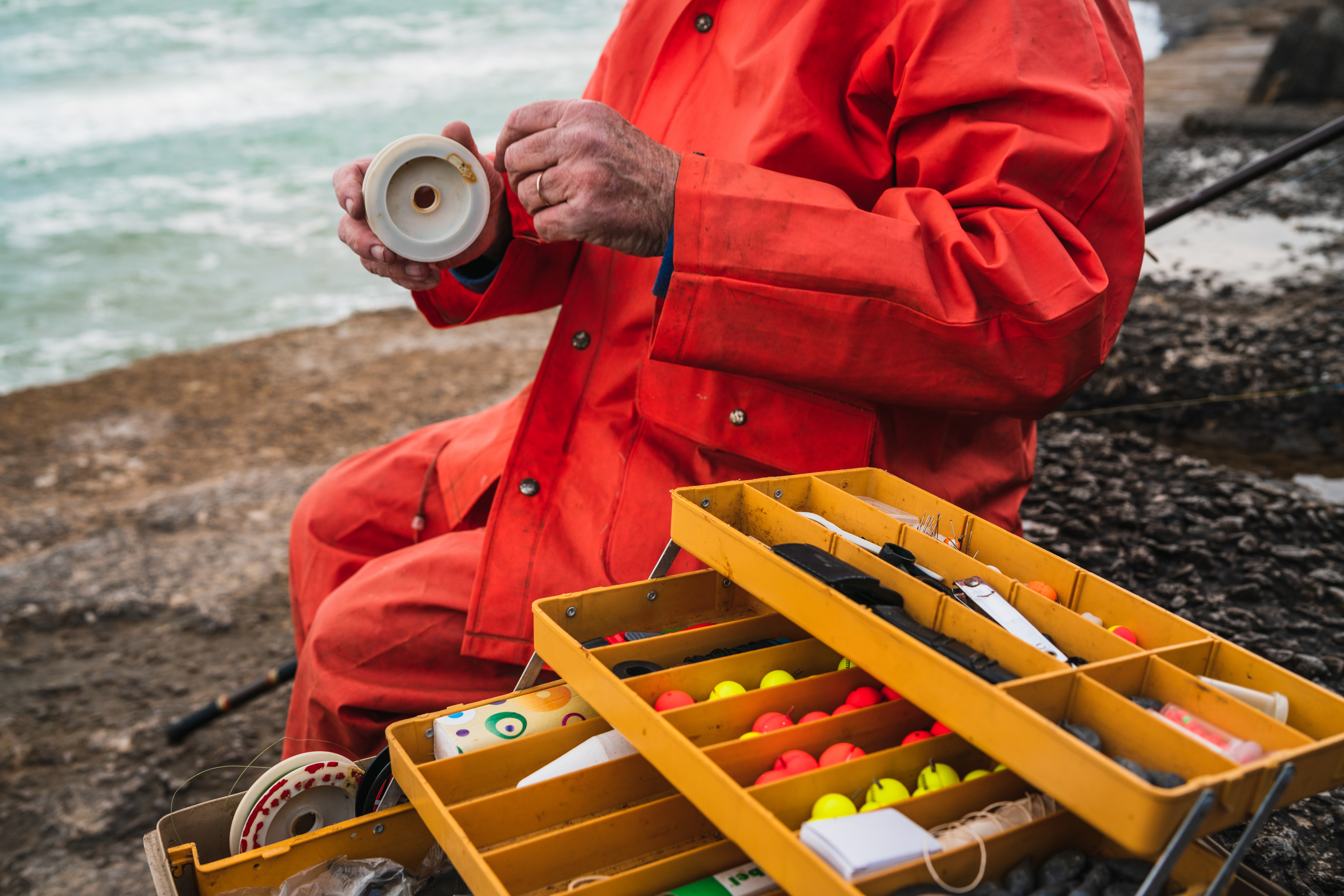 close-up-fisherman-putting-bait-with-fishing-equipment-box-fishing-sport-concept